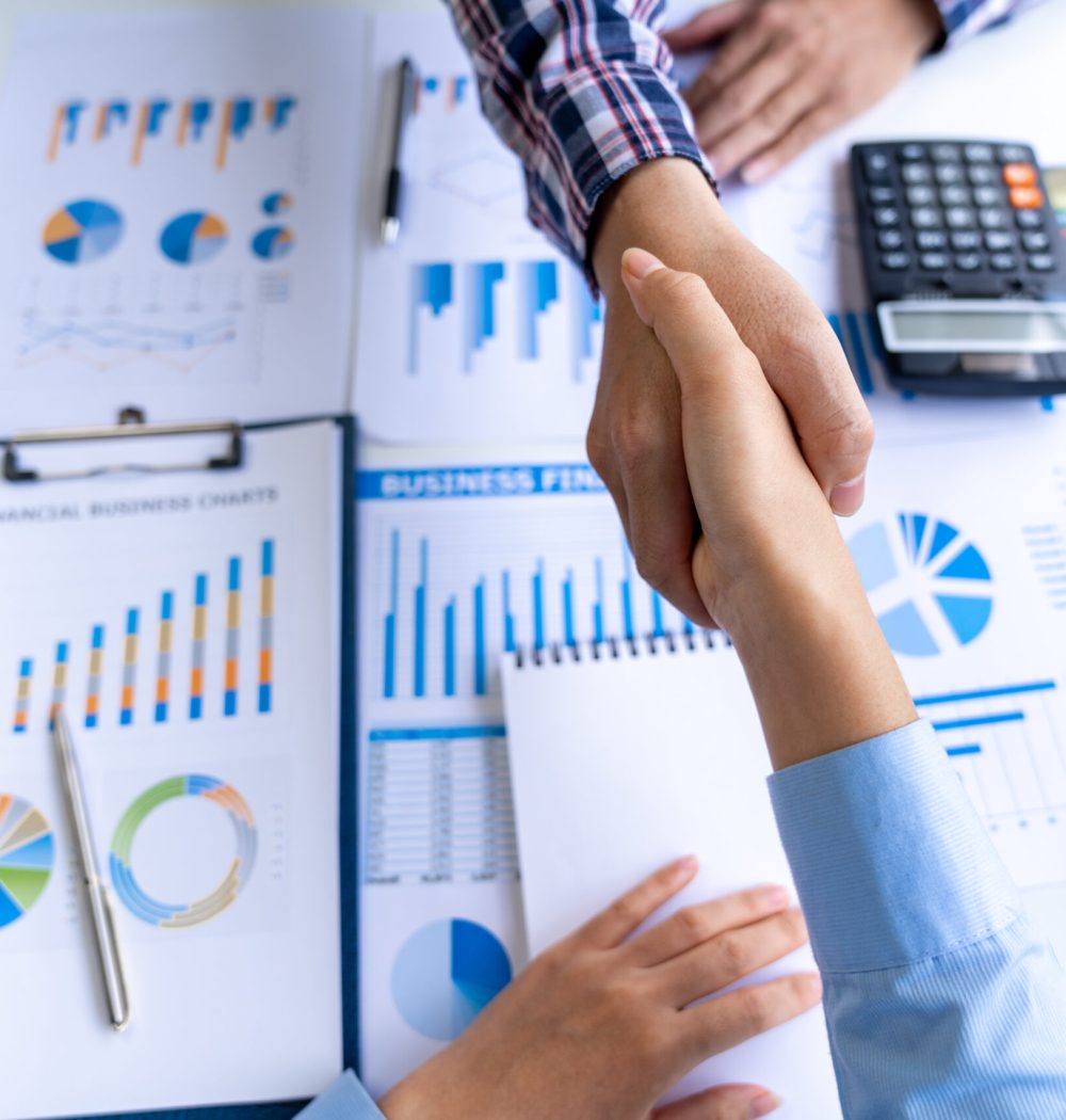 Young Asian businessmen and women shake hands as a team or greet each other at the office after a project. Successful in real estate business, finance, and new business ideas.